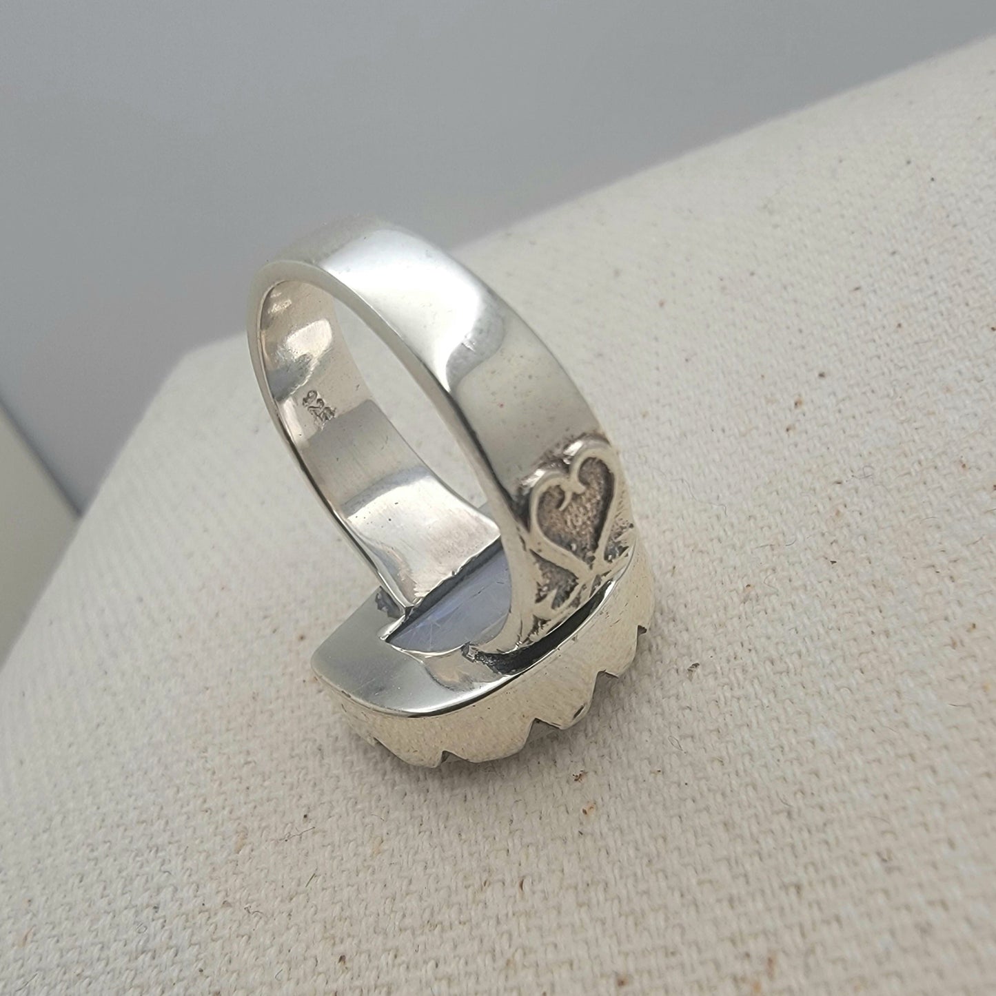 Size 8.5 sterling silver ring featuring a 10×15 mm half-moon moonstone set in a scalloped bezel on a tapered band.