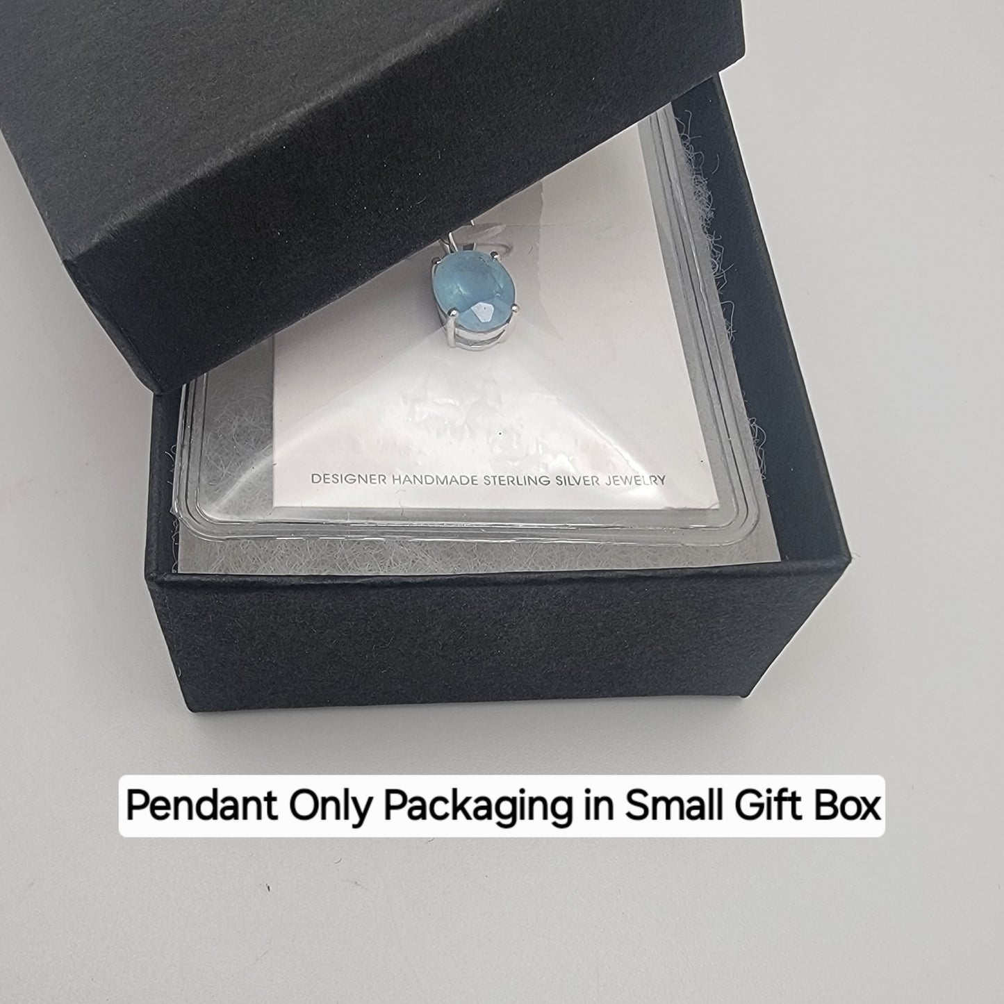 Aquamarine Jewelry pendant in a small black gift box on a white background