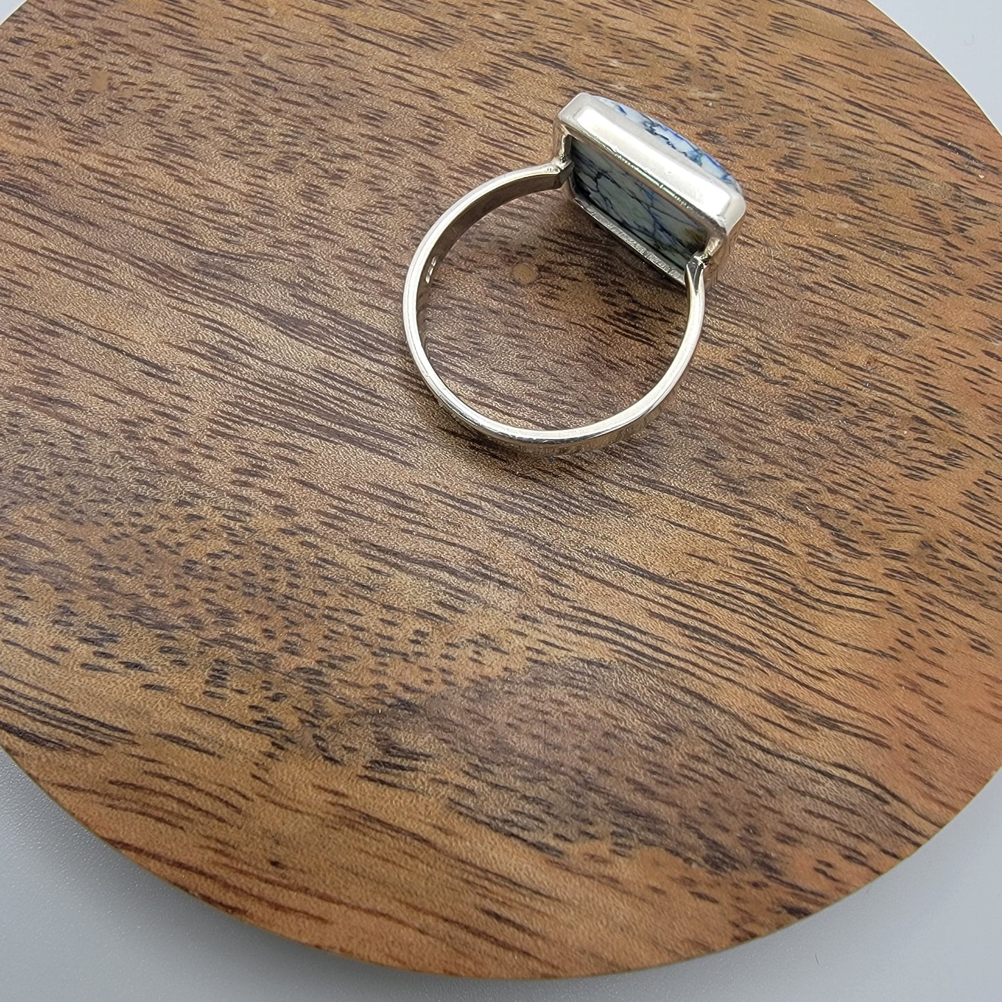 Silver ring on a wooden circular platform