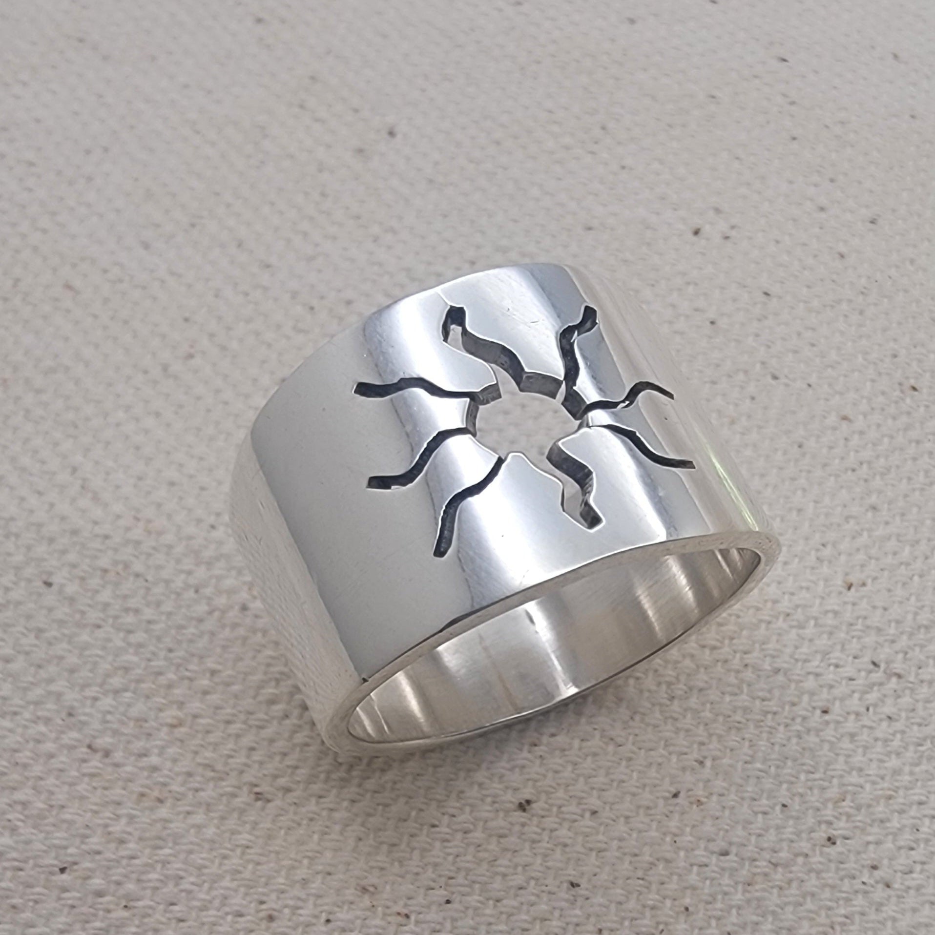 Close-up view of the 925 Sterling Silver Wideband Sunburst Ring showcasing its striking sun cutout design on a bold silver band. This artisan jewelry piece is perfect for casual wear, adding a modern touch to your summer jewelry collection with its unique silver ring style.