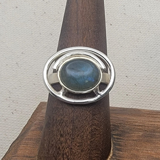 Labradorite Ring 925 Sterling Silver Statement Ring showcased on a wooden display, perfect for casual jewelry lovers. This unique design makes it an ideal Gift for Her or Gift for Him, enhancing any outfit with its elegant shine. A stunning statement ring crafted in Sterling Silver.