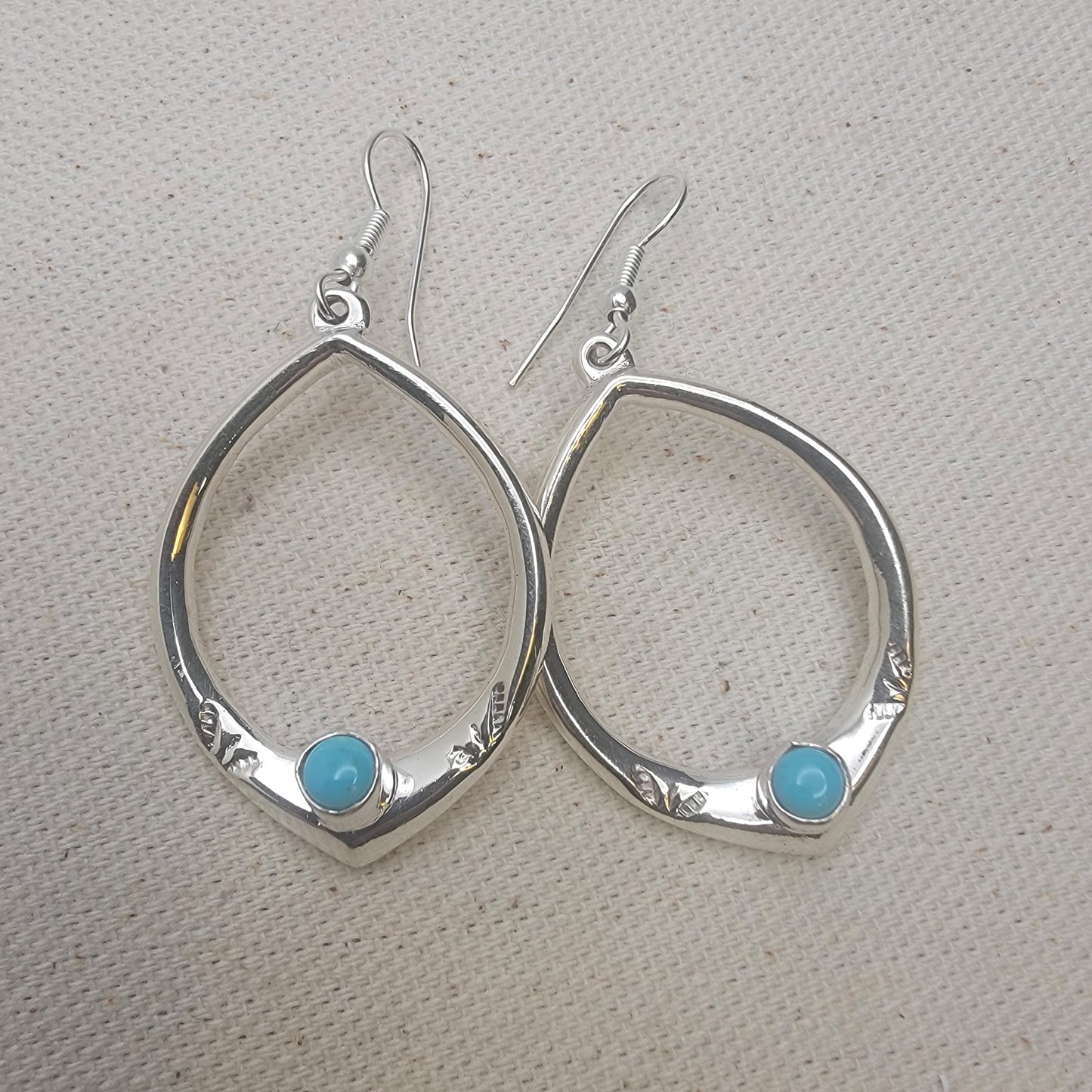 Teardrop Sterling Silver Earring with Turquoise Cabochon on neutral background
