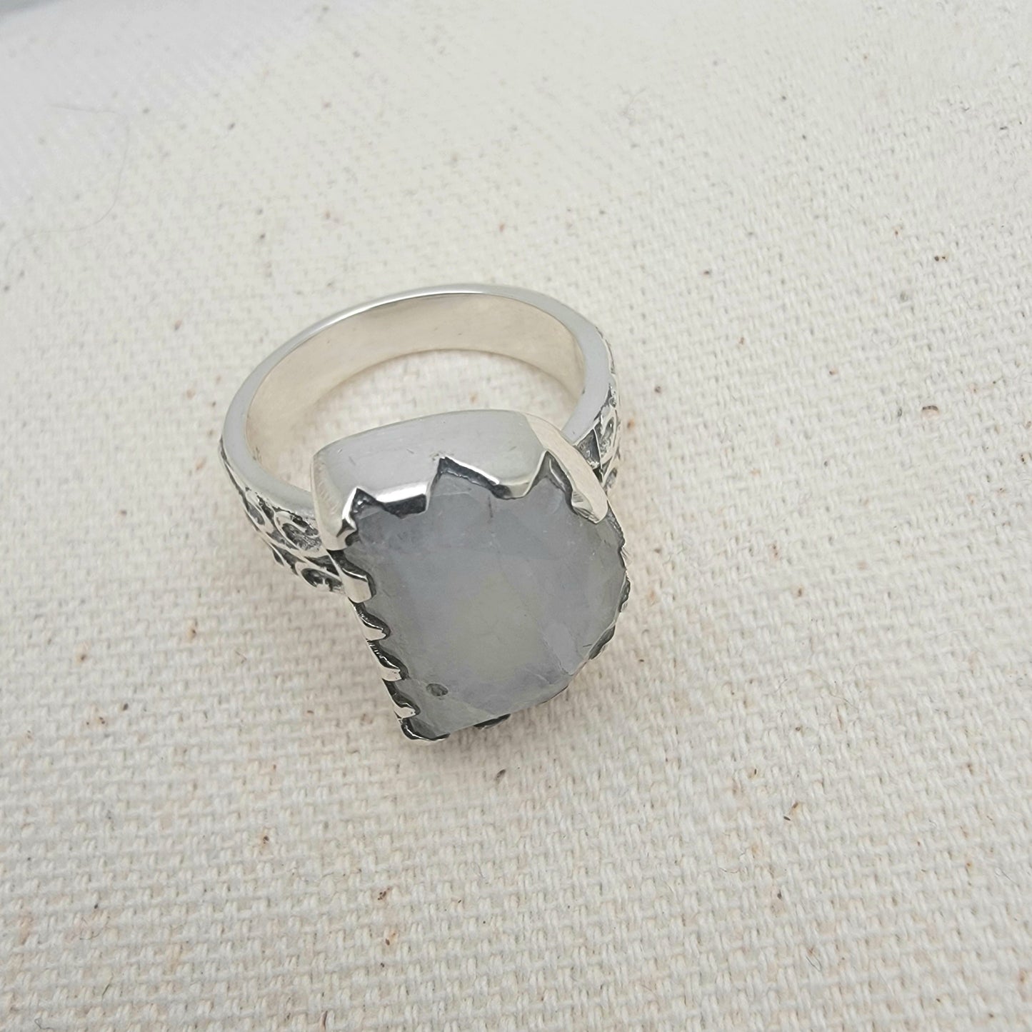Size 8.5 sterling silver ring featuring a 10×15 mm half-moon moonstone set in a scalloped bezel on a tapered band.