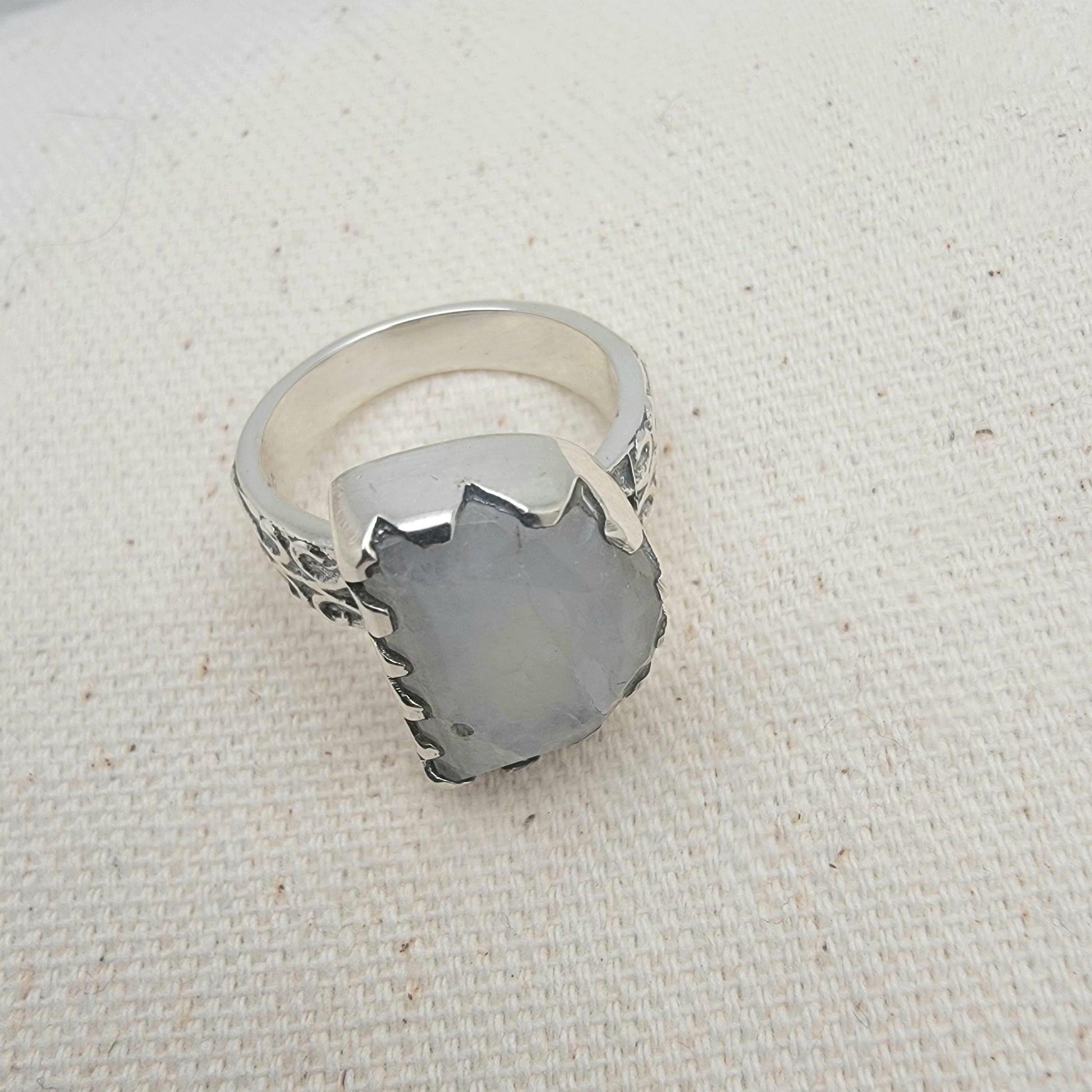 Size 8.5 sterling silver ring featuring a 10×15 mm half-moon moonstone set in a scalloped bezel on a tapered band.