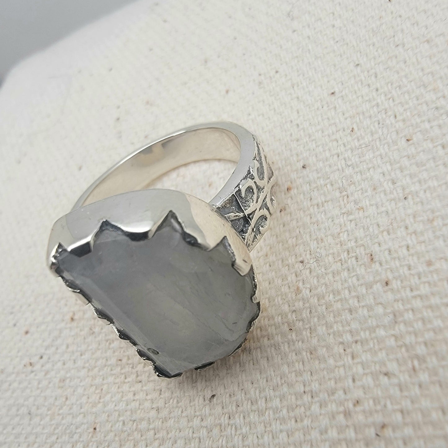 Size 8.5 sterling silver ring featuring a 10×15 mm half-moon moonstone set in a scalloped bezel on a tapered band.