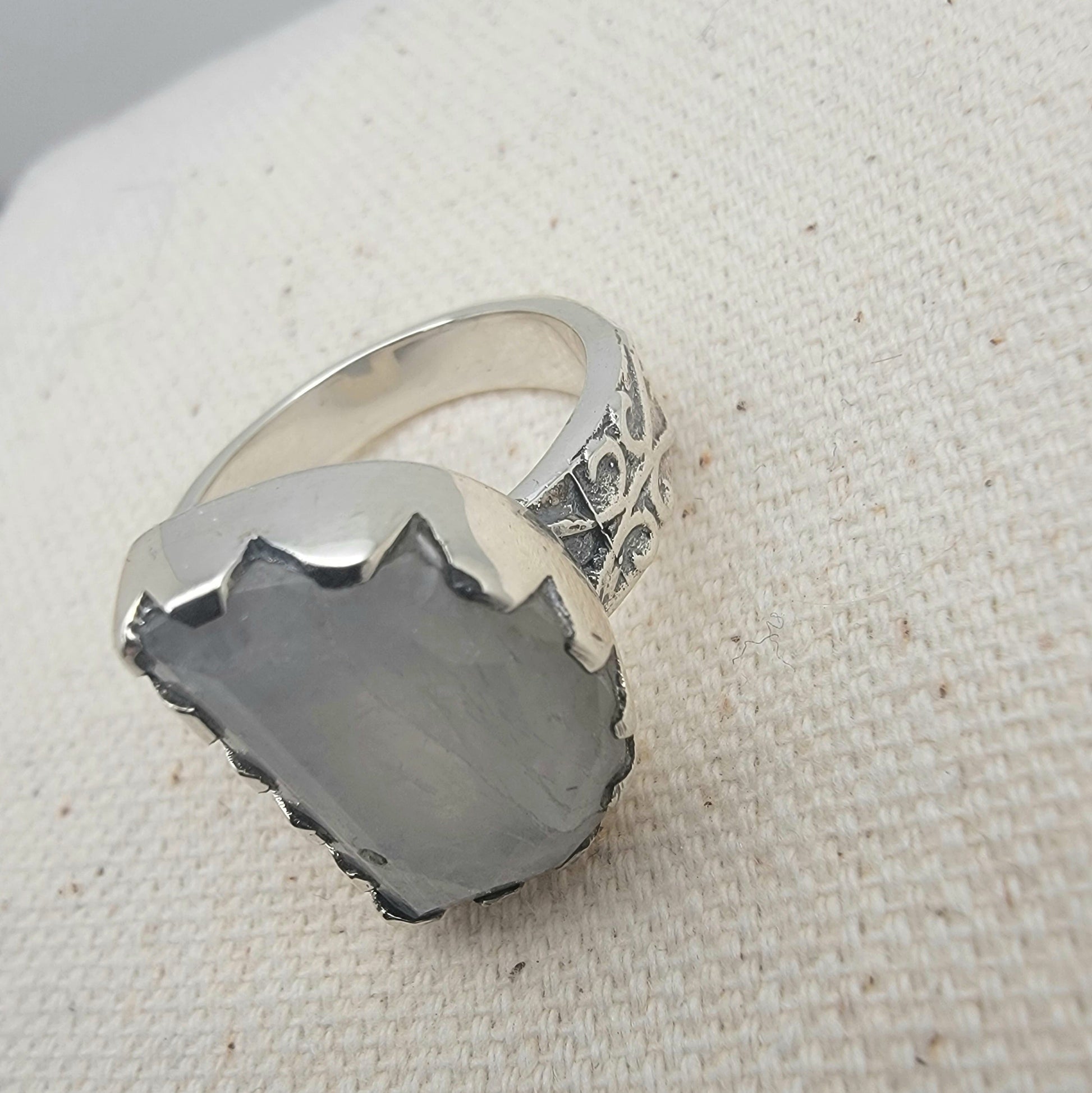 Size 8.5 sterling silver ring featuring a 10×15 mm half-moon moonstone set in a scalloped bezel on a tapered band.