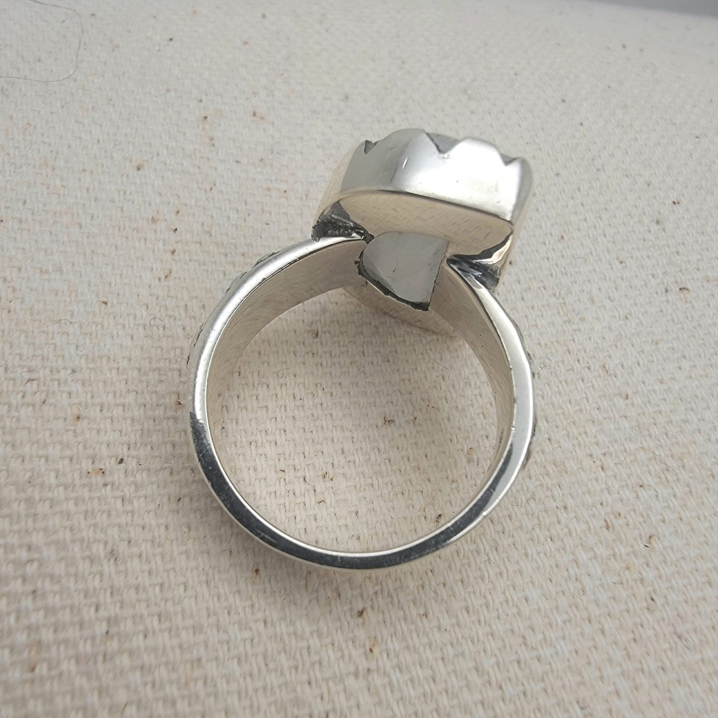 Size 8.5 sterling silver ring featuring a 10×15 mm half-moon moonstone set in a scalloped bezel on a tapered band.