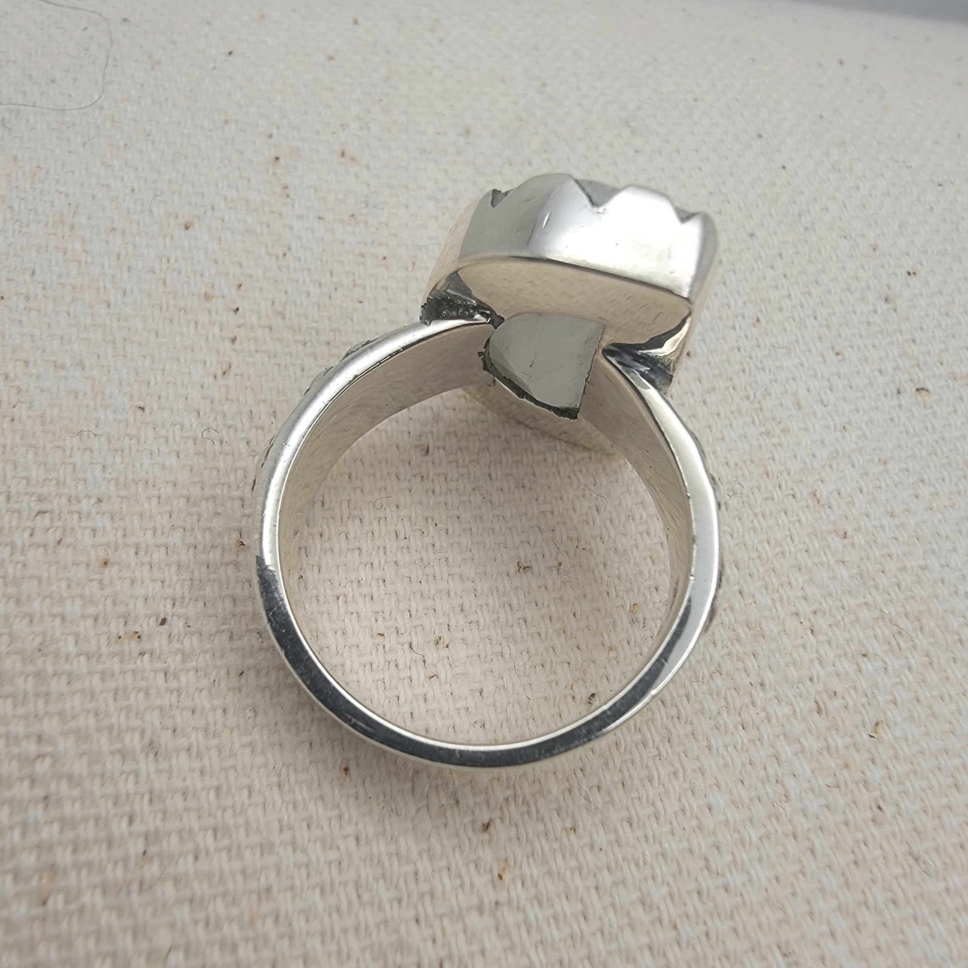 Size 8.5 sterling silver ring featuring a 10×15 mm half-moon moonstone set in a scalloped bezel on a tapered band.