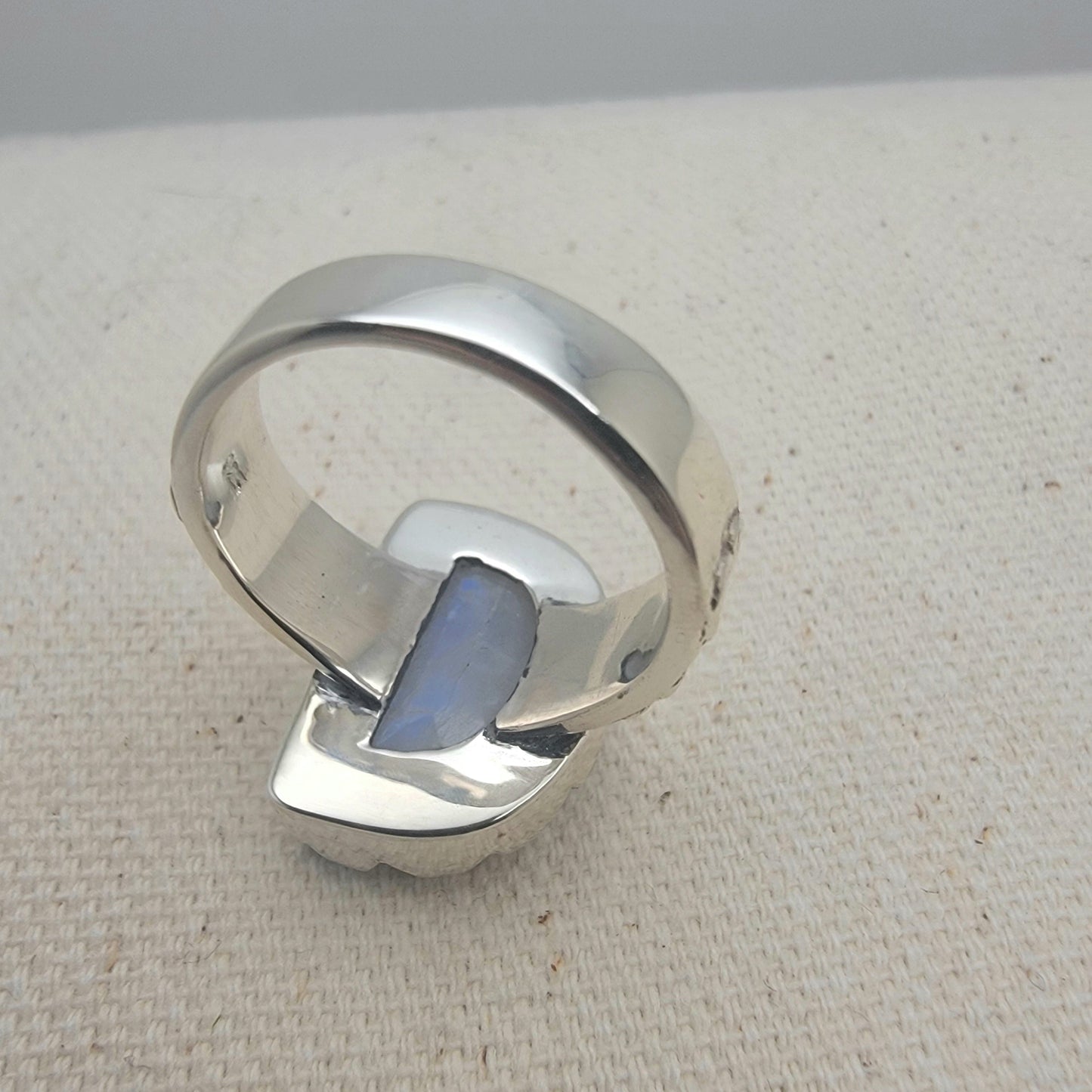 Size 8.5 sterling silver ring featuring a 10×15 mm half-moon moonstone set in a scalloped bezel on a tapered band.