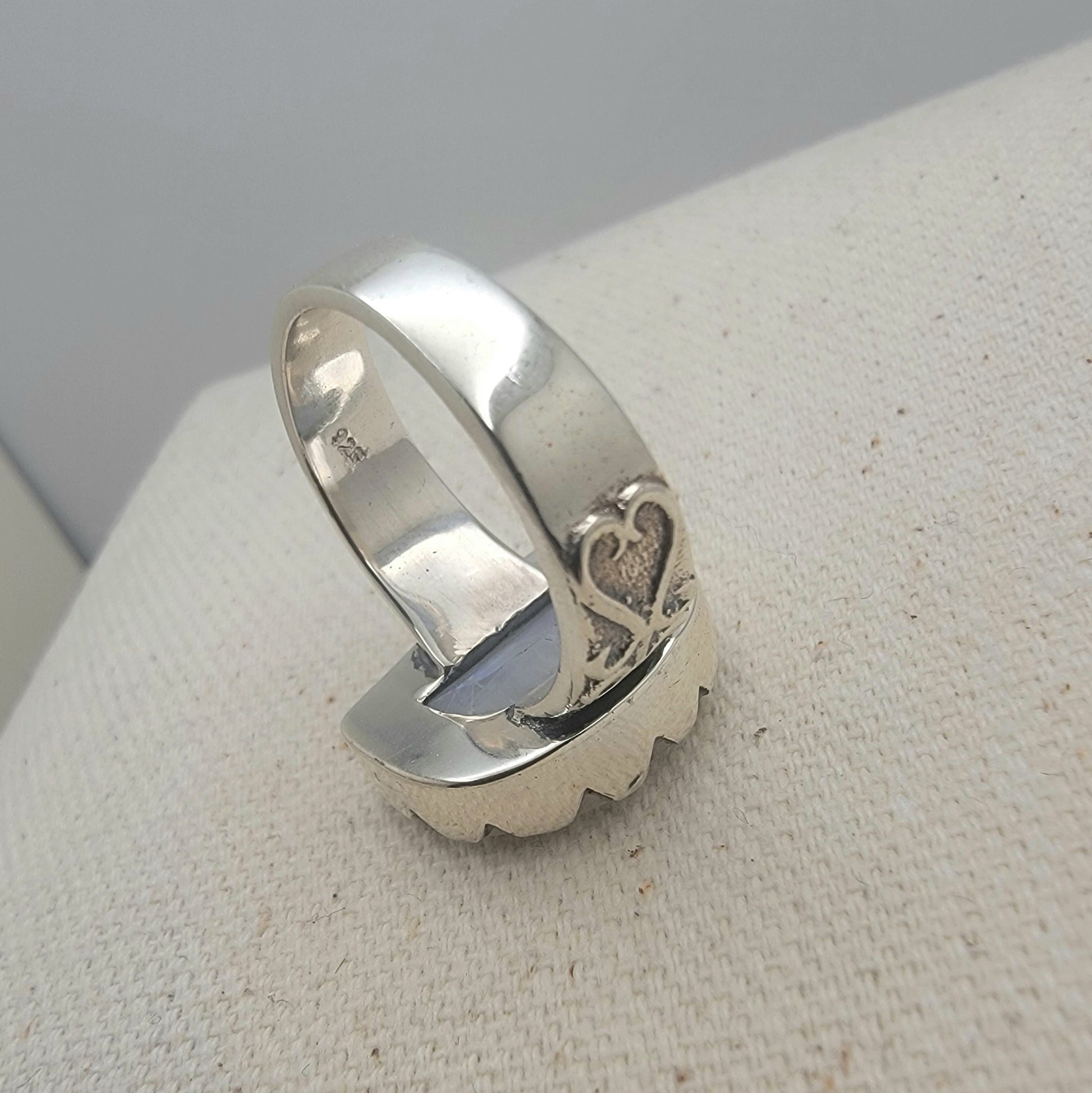 Size 8.5 sterling silver ring featuring a 10×15 mm half-moon moonstone set in a scalloped bezel on a tapered band.