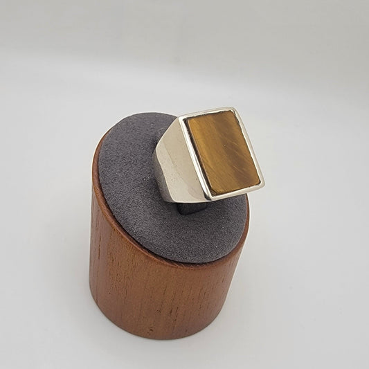 Silver ring with rectangular tiger's eye cabochon in grey and wooden stand