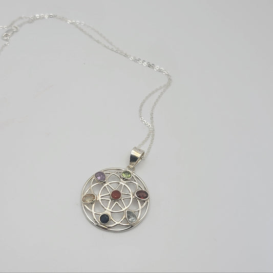 Silver necklace with a circular pendant featuring colorful stones on a light gray background