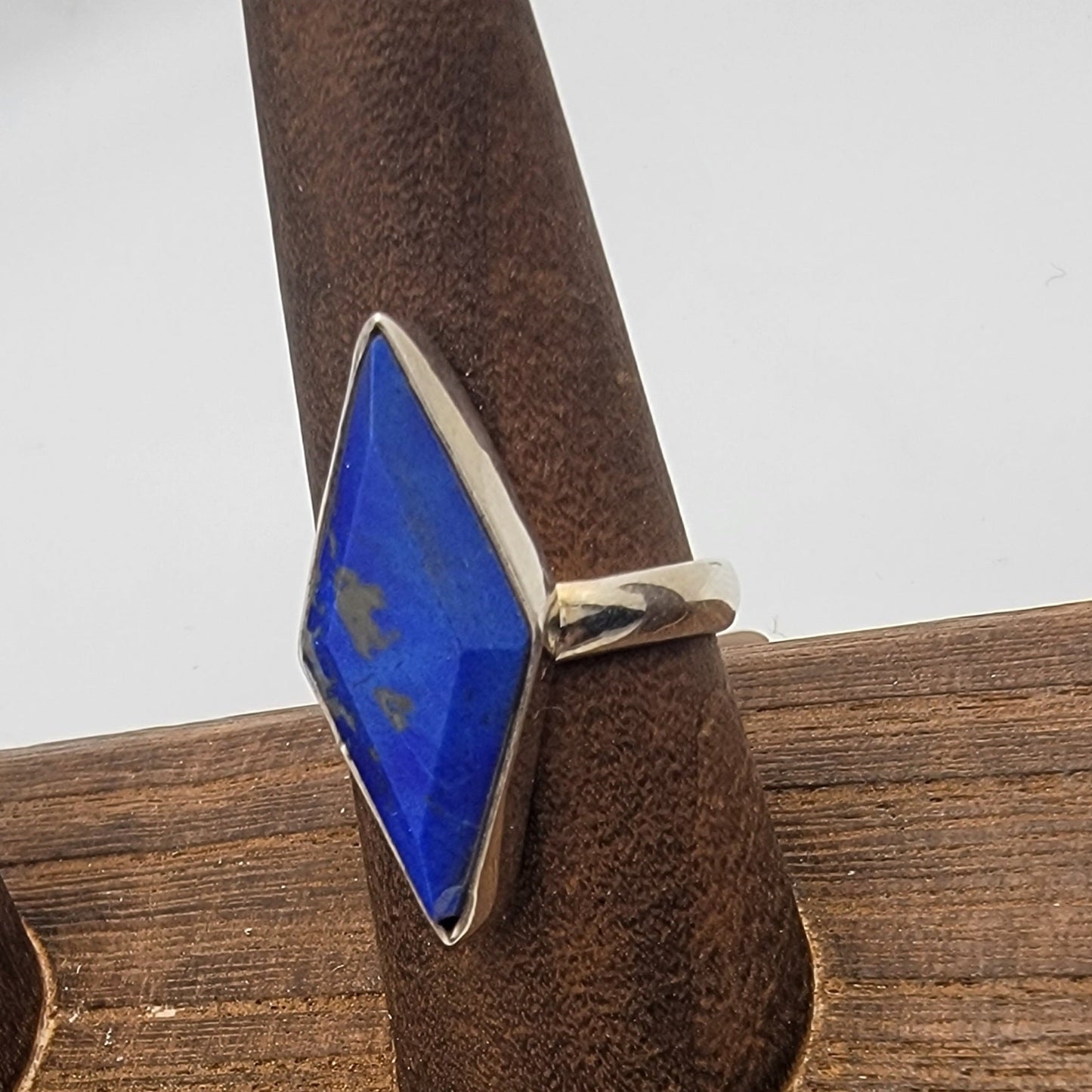 Silver ring with a blue lapis stone on a wooden surface