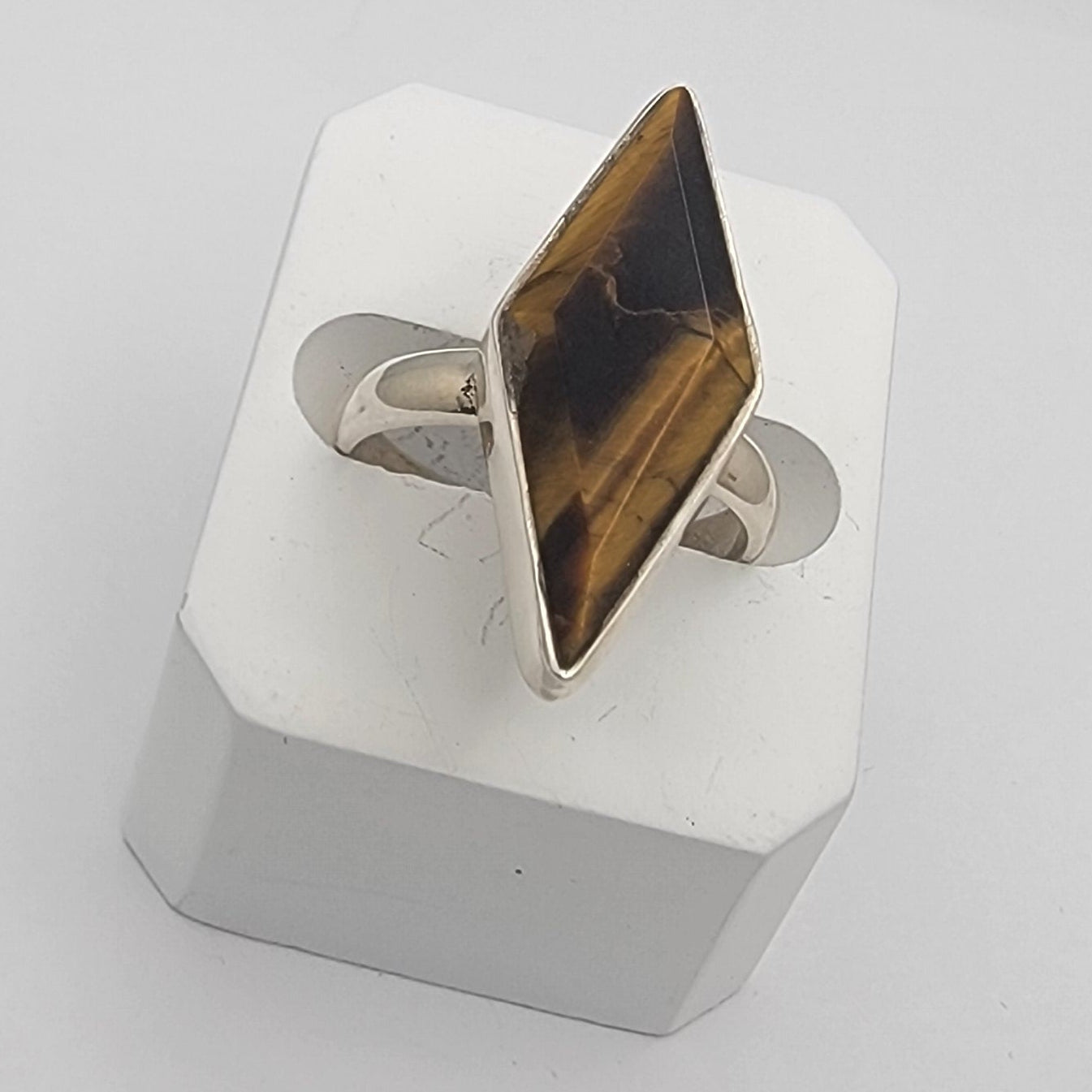 Tiger's eye cabochon sterling silver ring band on white background