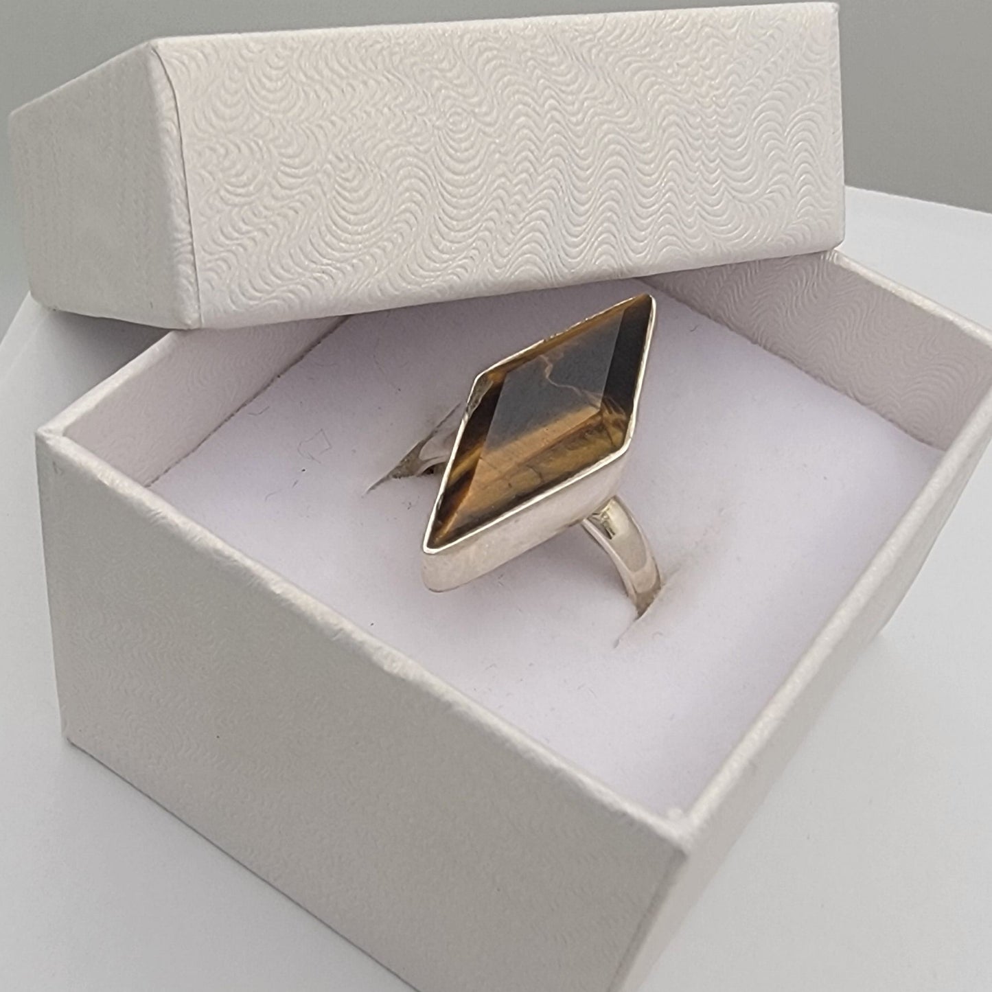 Sterling silver ring in a white box on a light gray surface