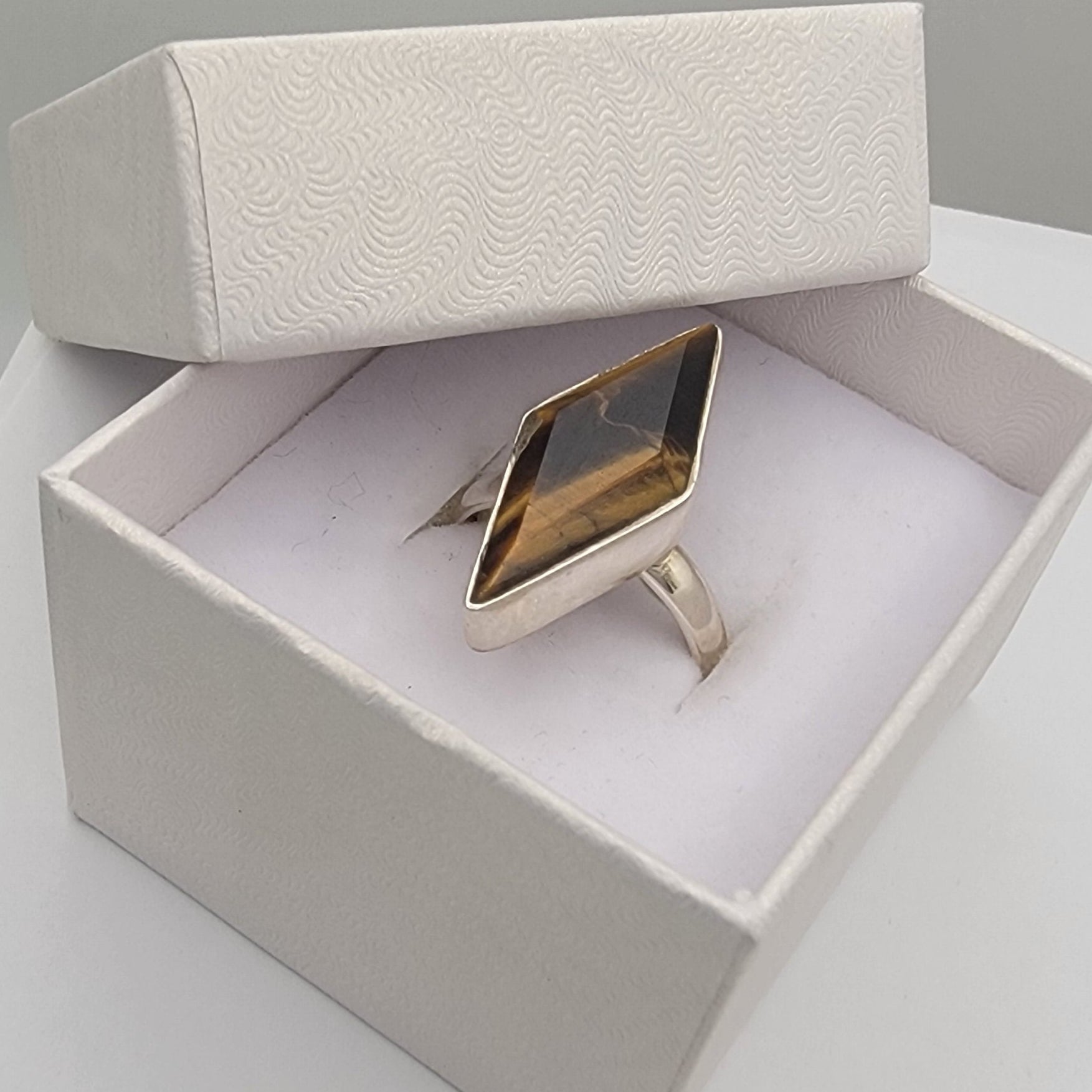 Sterling silver ring in a white box on a light gray surface